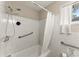 Bright white tiled bathroom and shower with modern fixtures and assist bars for accessibility at 2756 Gresham Se Rd, Atlanta, GA 30316