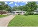Single-story home featuring a well-maintained lawn, a long driveway, and mature trees in the background at 2756 Gresham Se Rd, Atlanta, GA 30316