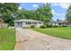 Single-story home boasts a spacious front yard with mature trees, a long driveway, and a welcoming exterior at 2756 Gresham Se Rd, Atlanta, GA 30316