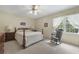 Neutral bedroom showcasing a wooden bed frame, matching dresser, rocking chair and natural light at 291 N Briar Rdg, Woodstock, GA 30189