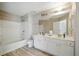 Bright bathroom with double vanity, tub, and shower, featuring wood-look flooring at 760 Celeste Sw Ln, Atlanta, GA 30331