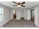 This light-filled bedroom boasts a ceiling fan and plush carpet at 409 Ivy Terrace Dr, Dallas, GA 30157