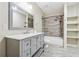 Charming bathroom featuring a marble countertop vanity, tiled shower, and open shelving for storage at 148 Copper Hills Dr, Canton, GA 30114