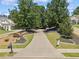 Well-manicured front yard with a long driveway leading up to a home surrounded by mature trees at 148 Copper Hills Dr, Canton, GA 30114