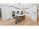 Bright kitchen with stone island, white cabinets, stainless appliances, seating and open design at 148 Copper Hills Dr, Canton, GA 30114