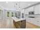 Bright kitchen with stone island, white cabinets, stainless appliances and a view to the backyard at 148 Copper Hills Dr, Canton, GA 30114