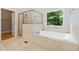 Relaxing bathroom featuring soaking tub, separate glass shower, and tiled floors creating a serene space at 148 Copper Hills Dr, Canton, GA 30114