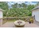The back deck with wood railing overlooks a wooded yard and has a built-in fire pit at 2005 Ashton Pointe Dr, Dacula, GA 30019