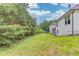 A grassy backyard sits between mature trees and the exterior of this home at 2005 Ashton Pointe Dr, Dacula, GA 30019