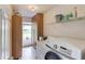Laundry room features a washer and dryer, cabinets, and shelves at 2005 Ashton Pointe Dr, Dacula, GA 30019