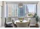 Cozy dining area with a round table set by large windows and city views at 215 Piedmont Ne Ave # 1001, Atlanta, GA 30308