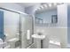 Bright bathroom with glass enclosed shower, white tiling, pedestal sink, and updated fixtures at 215 Piedmont Ne Ave # 2208, Atlanta, GA 30308