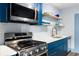 Well-lit kitchen featuring stainless steel appliances, a sleek cooktop, and stylish blue cabinetry at 215 Piedmont Ne Ave # 2208, Atlanta, GA 30308