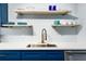 Kitchen featuring floating shelving above a sink with blue cabinetry below at 215 Piedmont Ne Ave # 2208, Atlanta, GA 30308