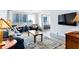 Bright living room with hardwood floors, comfortable seating, and scenic city views from large windows at 215 Piedmont Ne Ave # 2208, Atlanta, GA 30308
