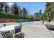 Outdoor pool area with lounge chairs, a table, and lush greenery, creating a relaxing retreat at 215 Piedmont Ne Ave # 2208, Atlanta, GA 30308