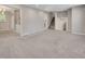 Large living area with stairs, kitchen doorway, and plush gray carpet at 2637 Elkhorn Dr, Decatur, GA 30034