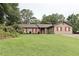 Charming single-story home with a well-manicured lawn, colorful landscaping, and inviting red shutters and door at 199 Candy Ln, Canton, GA 30115