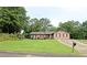 Charming ranch-style home featuring a lush front lawn, mature trees, and colorful flower beds for inviting curb appeal at 199 Candy Ln, Canton, GA 30115