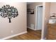 Neutral hallway with wood-look flooring, decorative picture tree on the wall, and trim at 199 Candy Ln, Canton, GA 30115