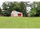 Spacious outbuilding with red accents and a garage door offers ample storage and potential workshop space at 199 Candy Ln, Canton, GA 30115