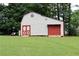 Spacious outbuilding with red doors for storage or workshop potential, set on a well-maintained lawn at 199 Candy Ln, Canton, GA 30115