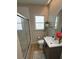 Modern bathroom with sleek glass-enclosed shower, gray vanity with roses and a bright window at 2413 N. Decatur Rd, Decatur, GA 30033