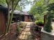 Charming brick home featuring a stone walkway, lush landscaping, and an elegant wrought iron arbor at 2413 N. Decatur Rd, Decatur, GA 30033