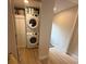 Convenient laundry room with stacked washer and dryer and storage cabinets on light wood flooring at 2413 N. Decatur Rd, Decatur, GA 30033