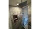 Elegant shower with marble tile, a rain shower head, a niche, and a modern glass door at 2413 N. Decatur Rd, Decatur, GA 30033