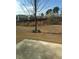 Backyard with bare grass, a small concrete patio and a young tree in the distance at 2955 Briaroak Dr, Duluth, GA 30096