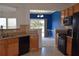 Kitchen with wood cabinets, black appliances, tile floors and view into a blue dining area at 2955 Briaroak Dr, Duluth, GA 30096