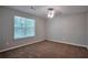 Neutral bedroom featuring plush carpet, ceiling fan, and bright window at 4879 Ardsley Dr, Lithonia, GA 30038