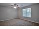 This spacious bedroom includes a ceiling fan, a large window, and soft carpet at 4879 Ardsley Dr, Lithonia, GA 30038