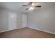 This neutral bedroom has soft carpet, a ceiling fan, and ample closet space at 4879 Ardsley Dr, Lithonia, GA 30038