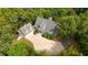 Expansive aerial view of a house with gray roof and a large driveway surrounded by verdant, mature trees at 2216 Trammel Rd, Cumming, GA 30041