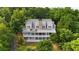 Aerial view of a beautiful home with a large porch and solar panels surrounded by lush greenery and mature trees at 2216 Trammel Rd, Cumming, GA 30041