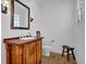 Charming powder room with wood vanity, framed mirror and stylish lighting at 2216 Trammel Rd, Cumming, GA 30041
