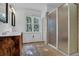 Bright bathroom featuring double sinks, framed mirrors, wood floors, and a glass shower at 2216 Trammel Rd, Cumming, GA 30041