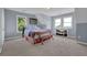 Serene bedroom with natural light, featuring a comfortable bed, carpet floors, and scenic views from the windows at 2216 Trammel Rd, Cumming, GA 30041