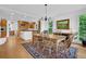 Open-concept dining room adjacent to kitchen, featuring a wooden table, chandelier, and hardwood floors at 2216 Trammel Rd, Cumming, GA 30041