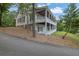 Charming home exterior showcasing a wrap-around porch, lush landscaping, and a basketball court at 2216 Trammel Rd, Cumming, GA 30041