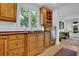 Well-lit kitchen features wooden cabinets, countertops, stainless steel dishwasher, and a window overlooking greenery at 2216 Trammel Rd, Cumming, GA 30041