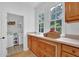 Bright laundry room featuring a washing machine and dryer, wooden cabinets, and a window with greenery view at 2216 Trammel Rd, Cumming, GA 30041