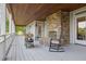 Inviting outdoor porch with a stone fireplace, rocking chair, wood ceiling and serene ambiance at 2216 Trammel Rd, Cumming, GA 30041