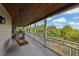 Expansive porch with a wooden ceiling, swing chair, and views of the surrounding nature at 2216 Trammel Rd, Cumming, GA 30041