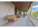 Inviting porch with swing, stone fireplace, wood ceiling and beautiful outdoor seating, perfect for relaxing at 2216 Trammel Rd, Cumming, GA 30041
