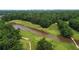 Aerial view of a meticulously designed golf course with a lake and tree-lined fairways, set against a city skyline at 2405 Hillside Ave, Decatur, GA 30032