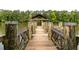 View of a wooden dock with a covered gazebo extending into a calm lake surrounded by lush green trees at 2405 Hillside Ave, Decatur, GA 30032