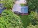 Aerial view shows a well maintained backyard, back deck, and home surrounded by mature trees at 3919 Valley Brook Rd, Snellville, GA 30039